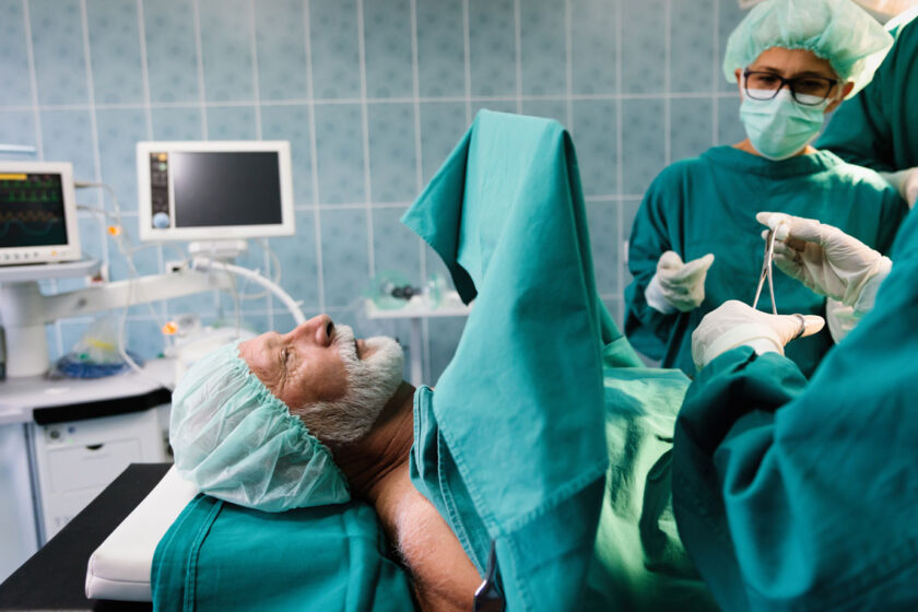 A man stares up as he lies on the operating table.